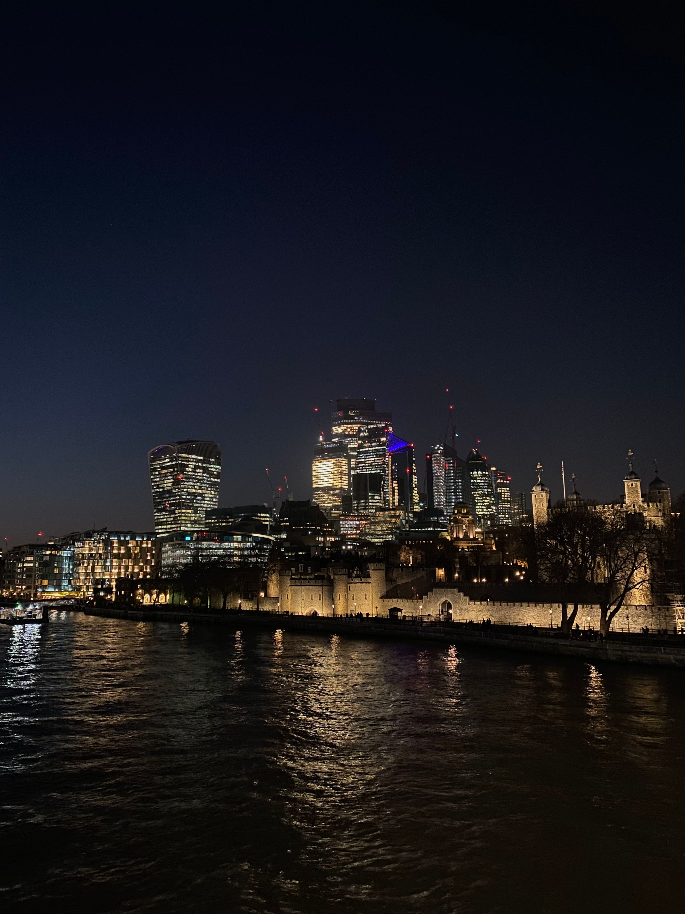 The illuminated Tower of London and the City skyline at night
